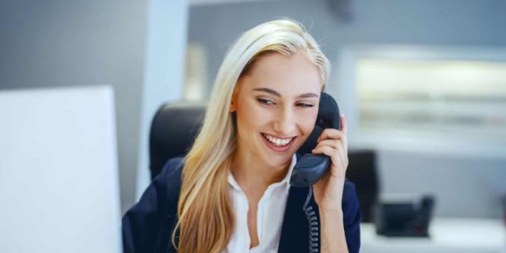 Employee-using-new-work-system-phone-to-make-client-calls (Custom) صف تماس